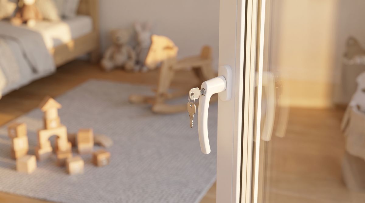 Detailaufnahme eines abschließbaren Fenstergriffs mit Schlüssel, Kindersicherung Fenster