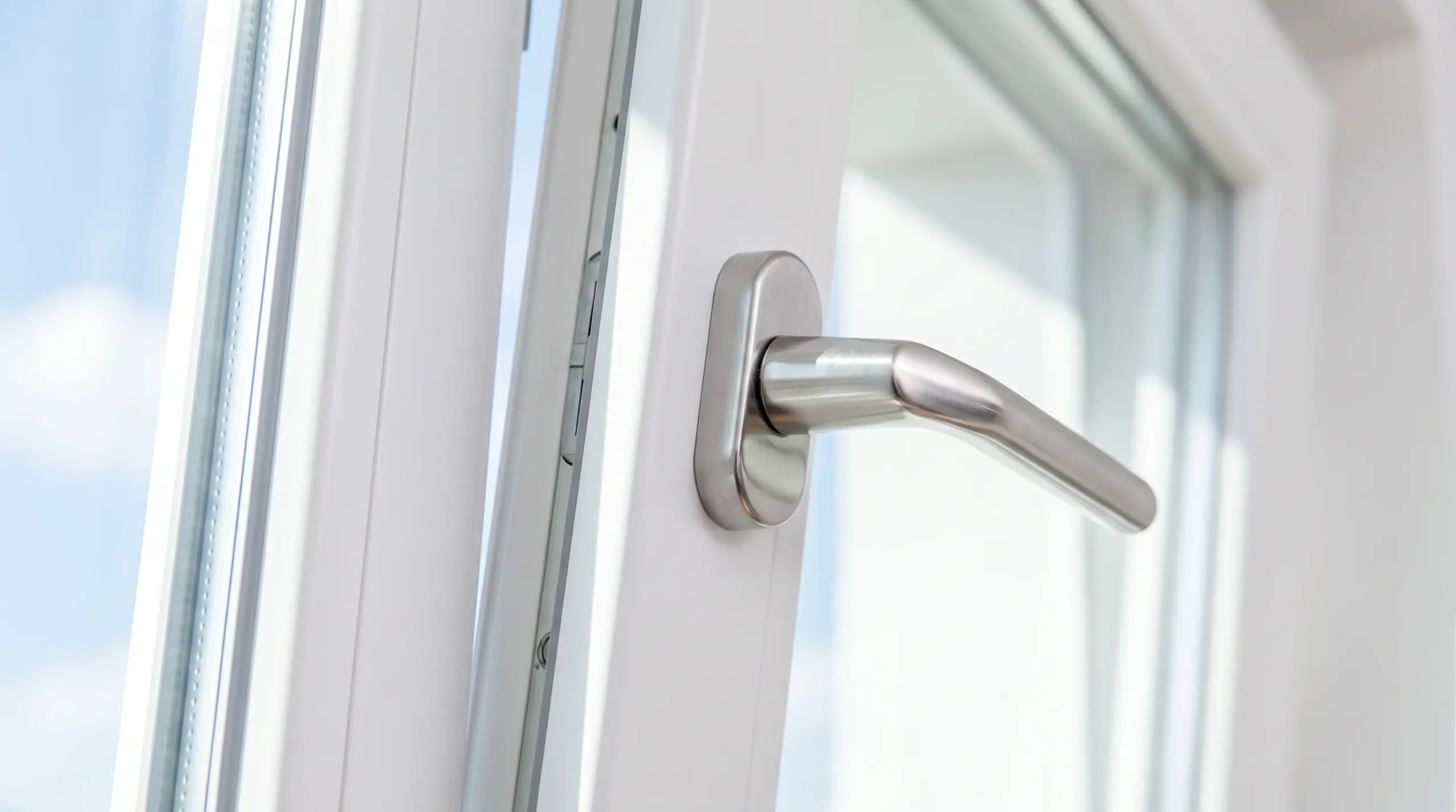 Fenster online konfigurieren – Nahaufnahme moderner Fenstergriff an weißem Kunststofffenster