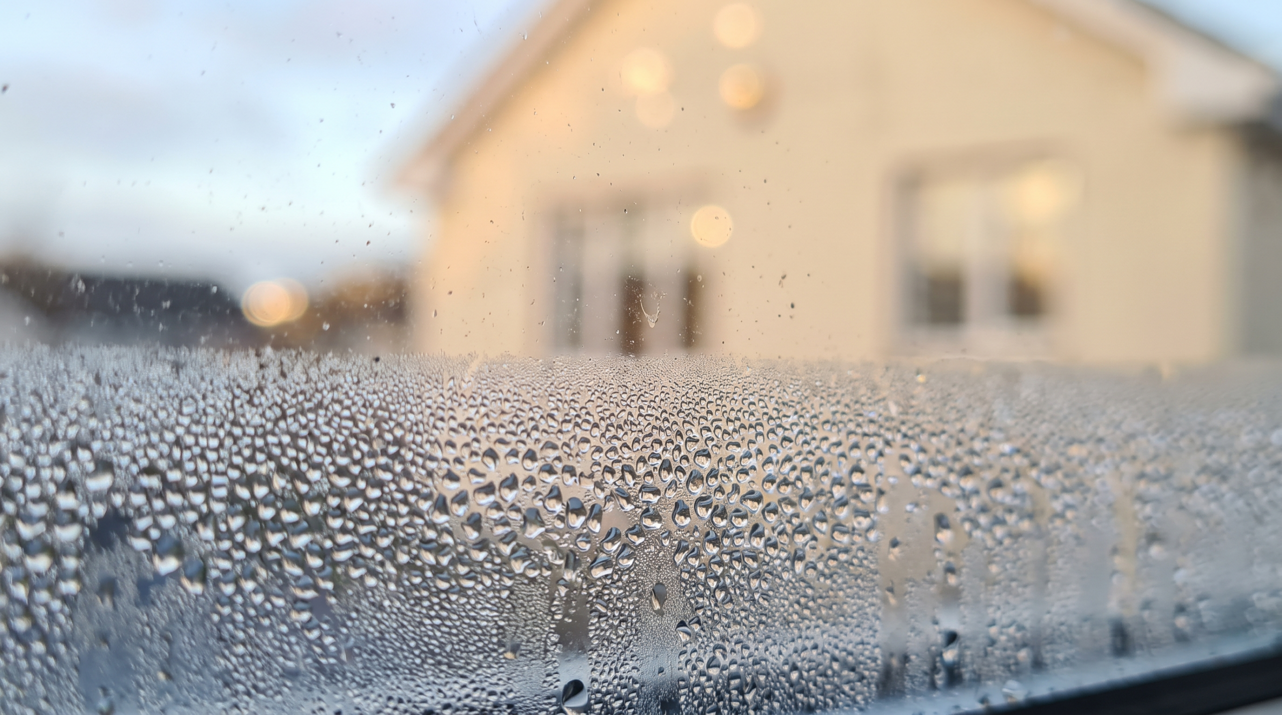 Fenster beschlagen von außen: Tauwasser auf der Außenscheibe eines Dreifachglas-Fensters im Morgenlicht